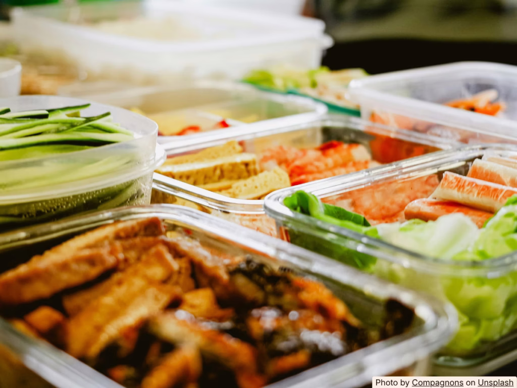Shallow containers of cookout leftovers being stored in a refrigerator