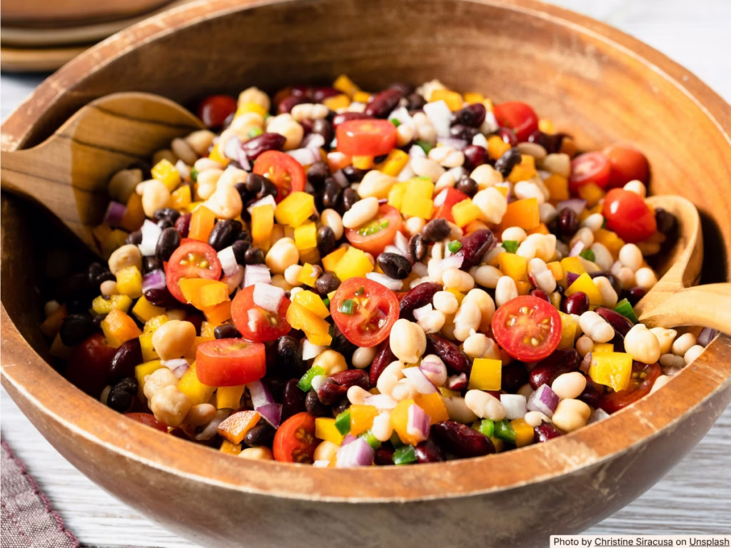 Fresh mango black bean salad with corn and red onion in a white bowl, topped with lime