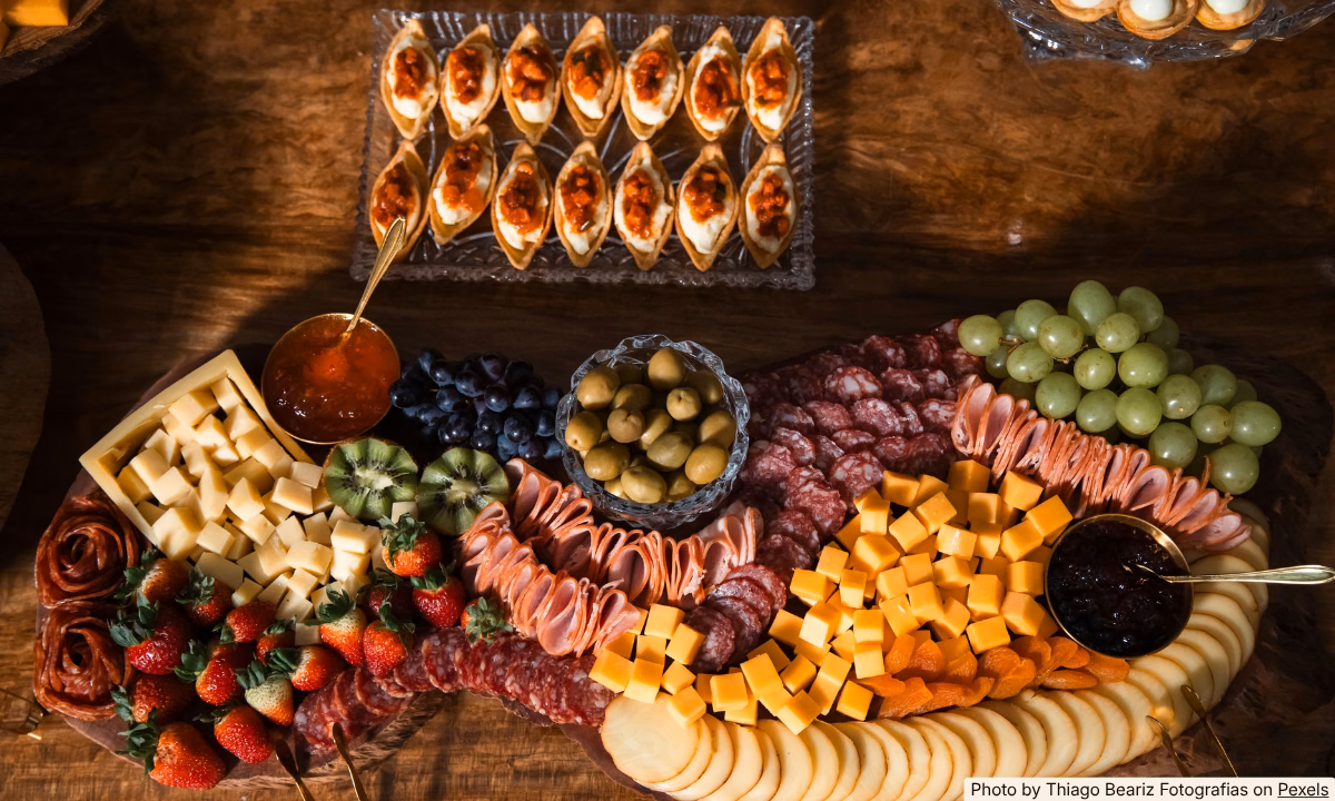 Budget World Cup watch party snack spread with hummus, fruit, chips, and pita on a casual table