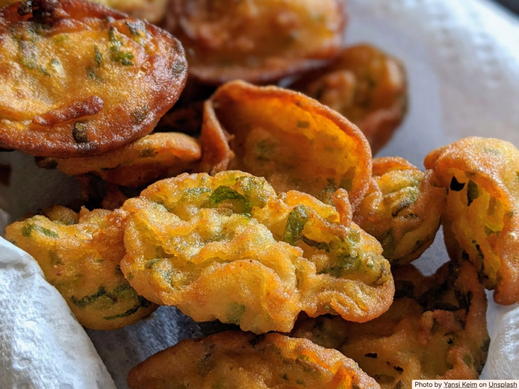 Golden zucchini fritters on a plate with sour cream, bright natural light, simple homemade cooking